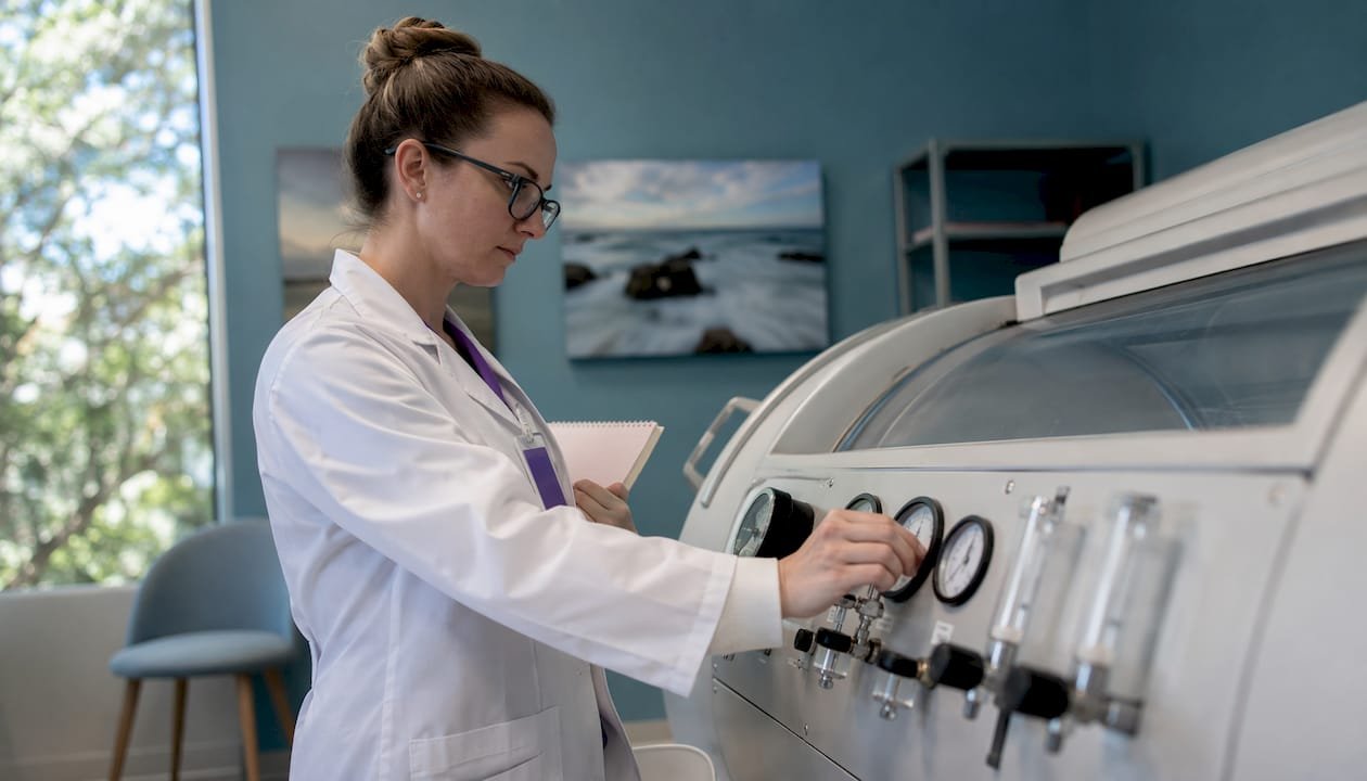 Technician setting hyperbaric oxygen therapy controls