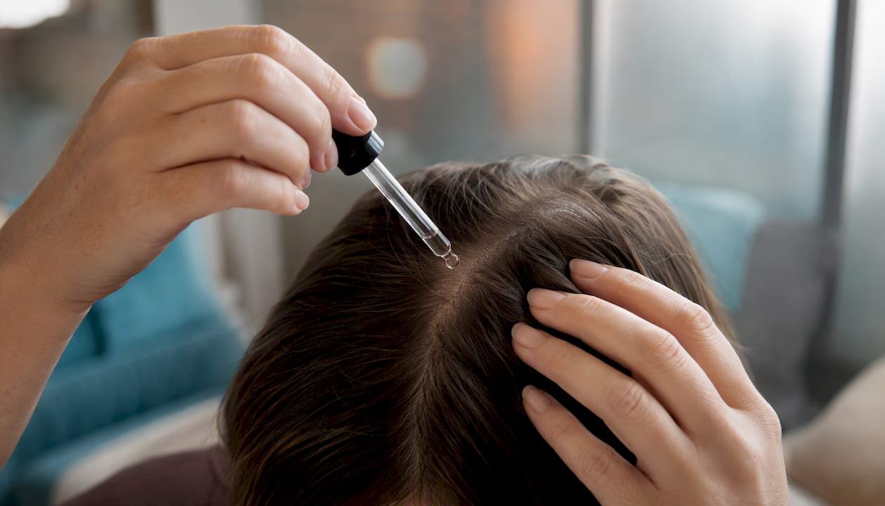 Applying topical minoxidil to scalp