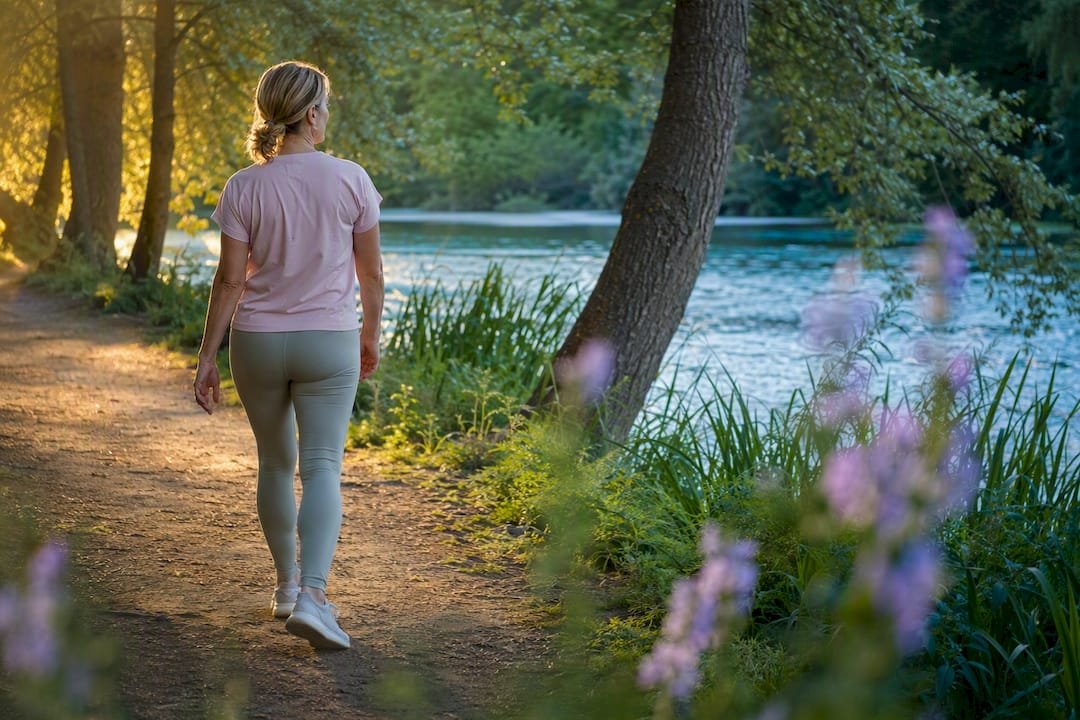 Woman walking on park path for recovery