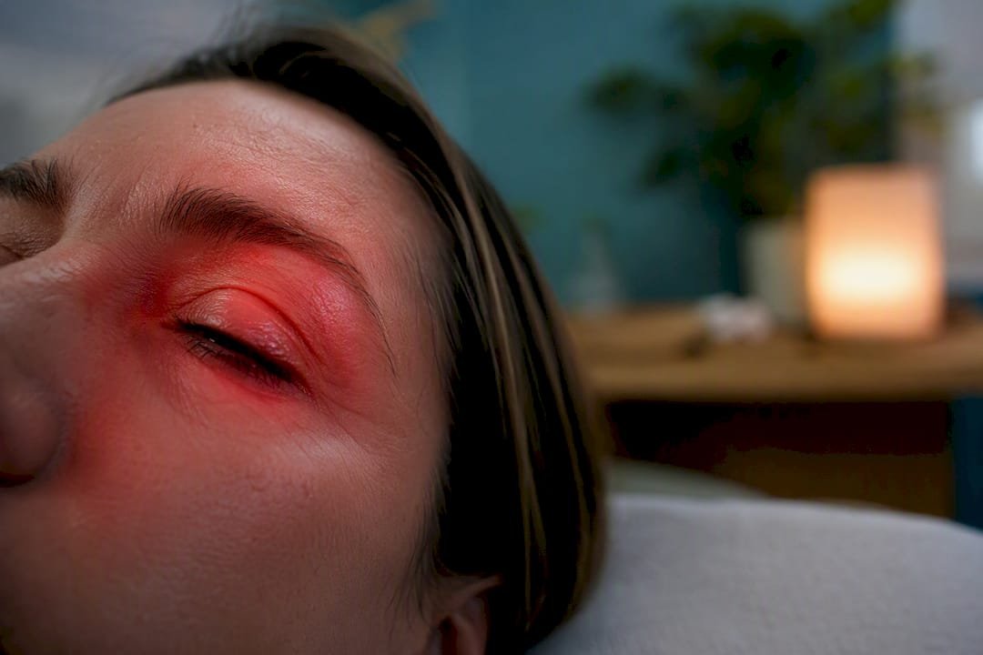 Close-up eye with soft red light nearby for safety context
