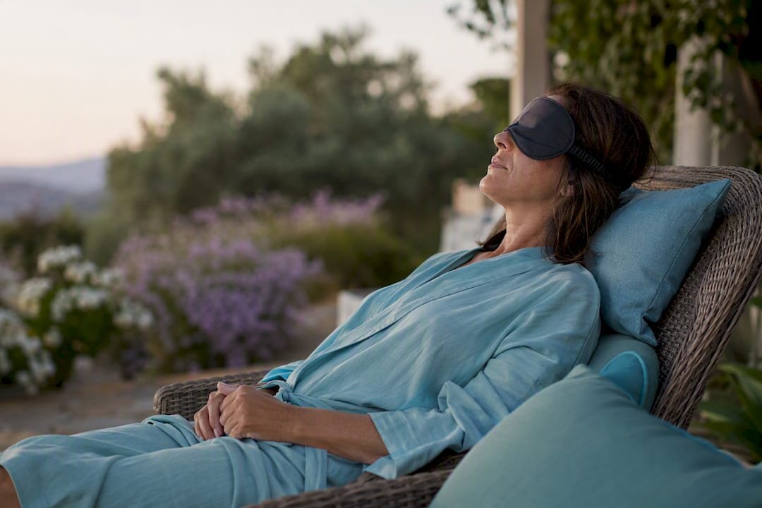 Woman resting with sleep mask in calming spa lounge