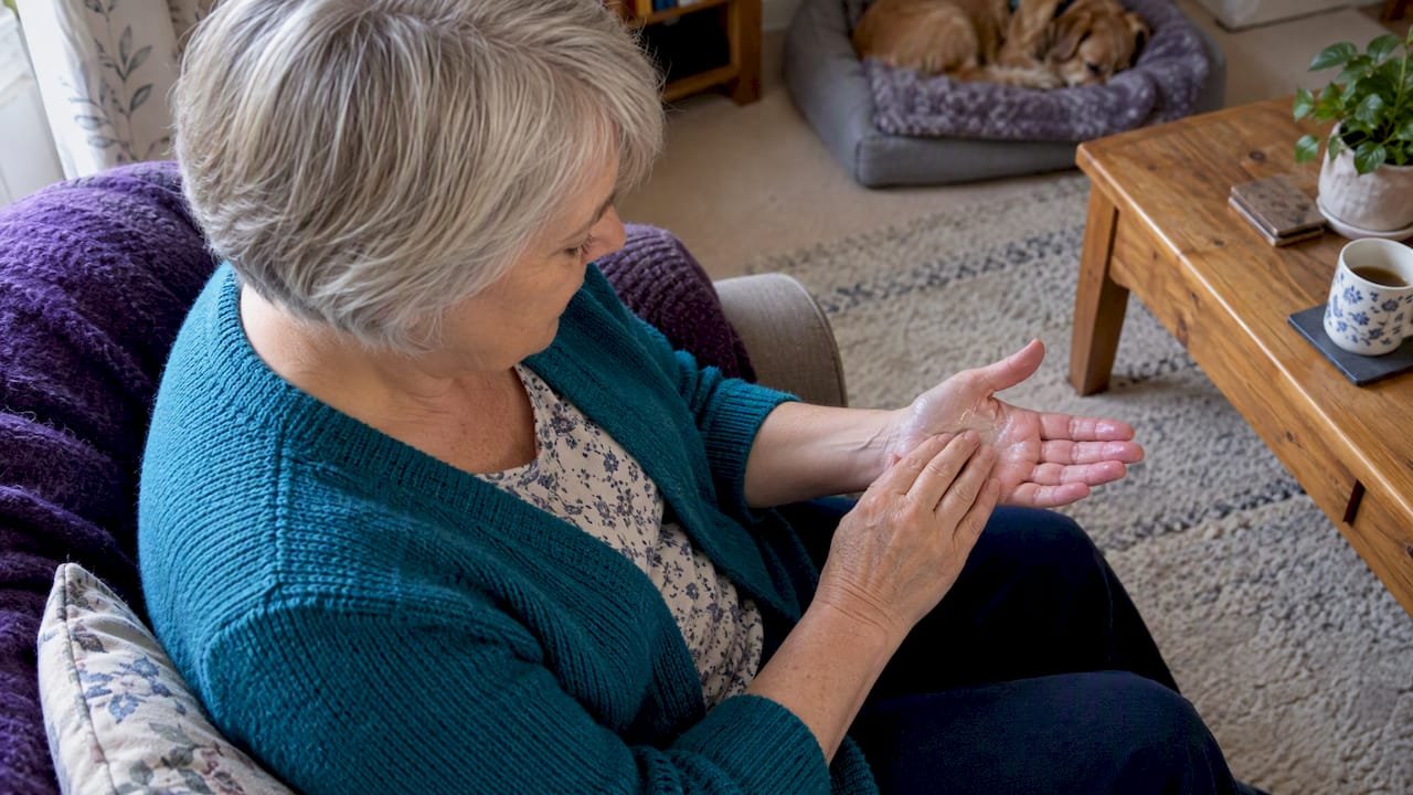 Woman gently massaging her palm at home